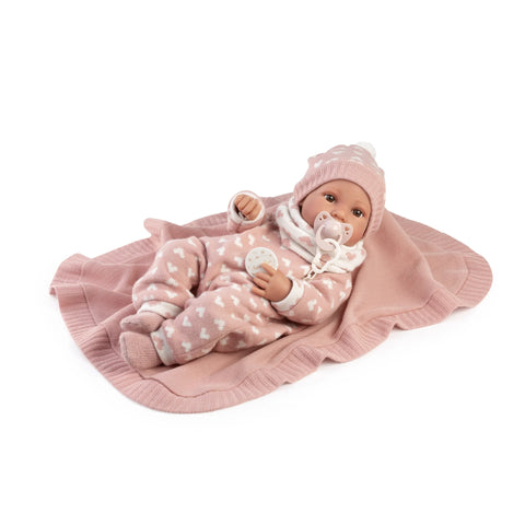 Muñeca Recién Nacida Erika de Antonio Juan con pelele rosa de corazones, gorro y chupete tumbada sobre su toquilla
