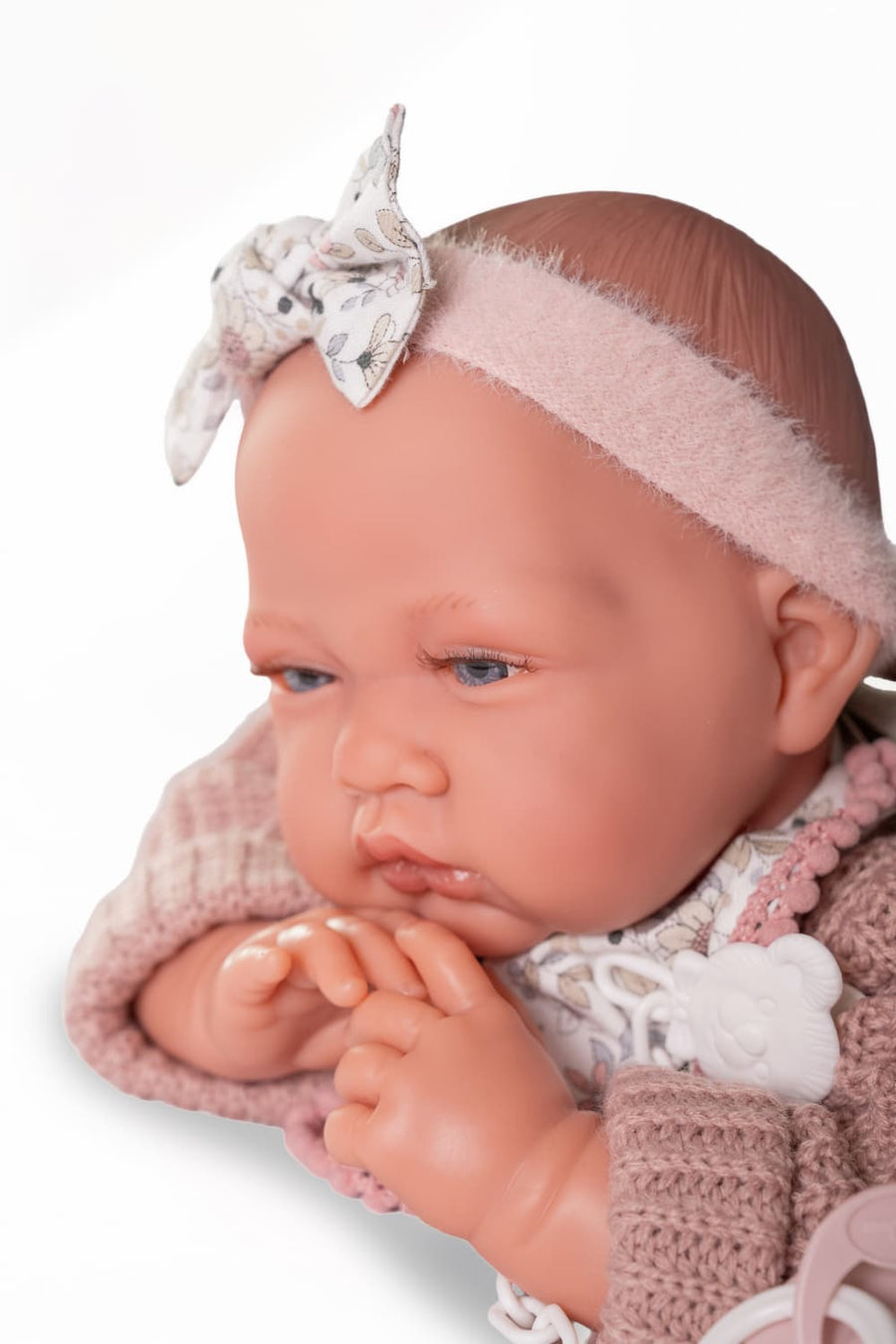 Muñeca Recién Nacida Lúa de Antonio Juan, primer plano de la cara con diadema rosa, lazo floral y chupete