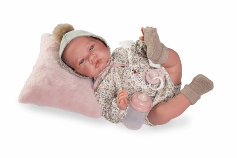 Lúa tumbada sobre su cojín con biberón y chupete

