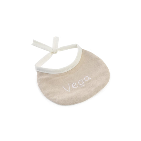 Babero beige bordado con el nombre Vega