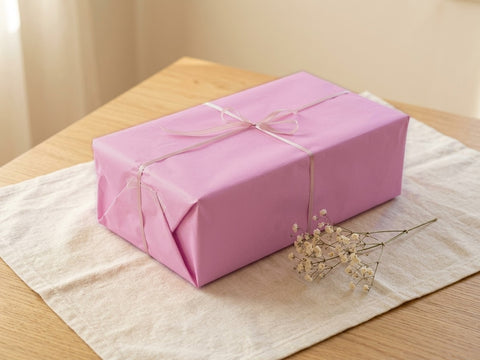 Envuelto para regalo de Antonio Juan Dolls: caja forrada en papel rosa con lazo de raso