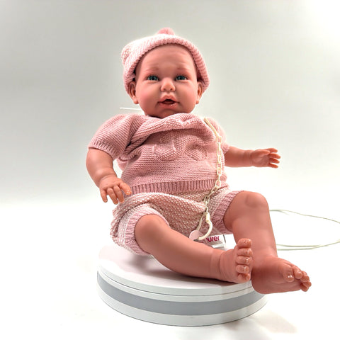 Mi Primer Reborn Daniella 81055 de Antonio Juan, foto real de frente: gorro de punto de rayas rosa y blanco, jersey rosa y chupete con cadena